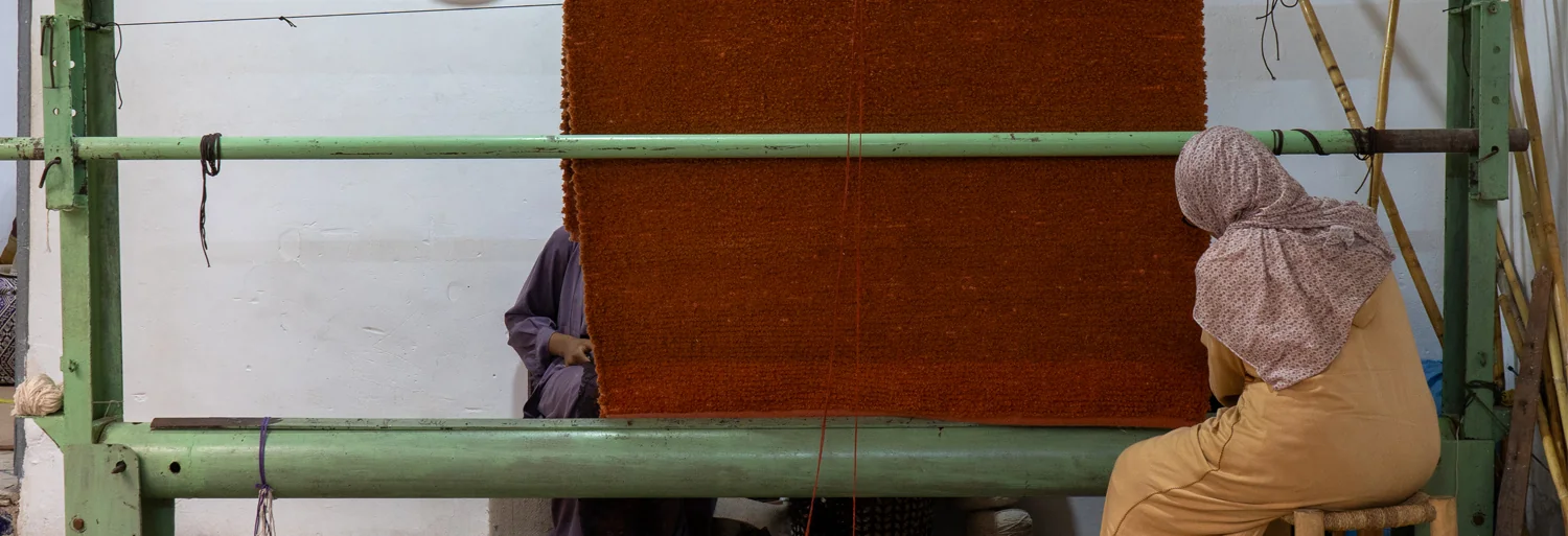 Tissage marocain sur métier à tisser, fils de laine aux tons terracotta